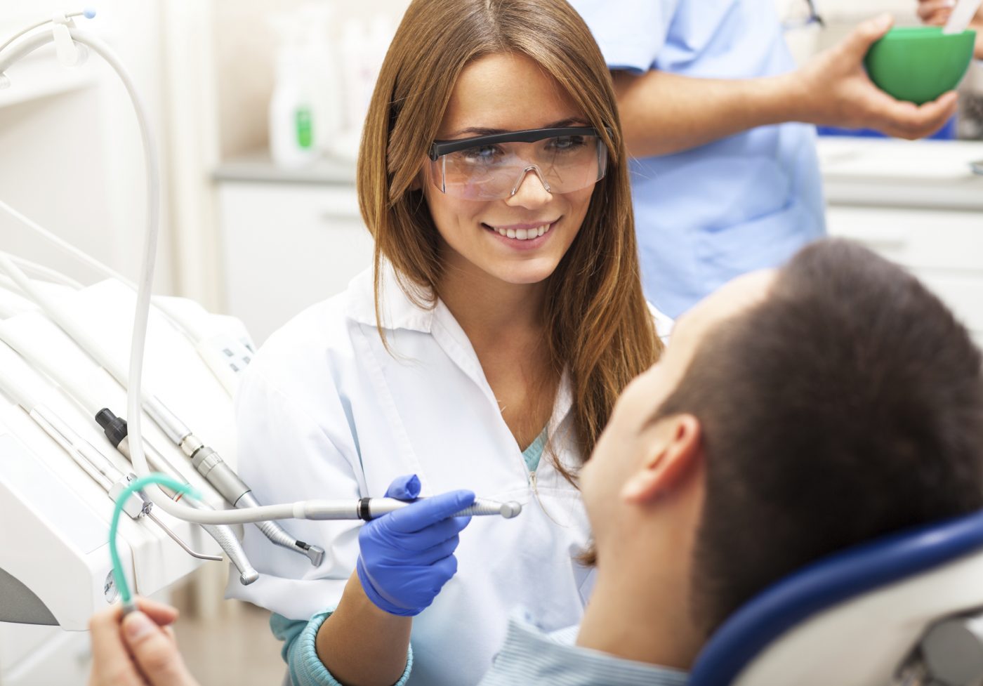 female dentist doing a routine dental cleaning for male patient