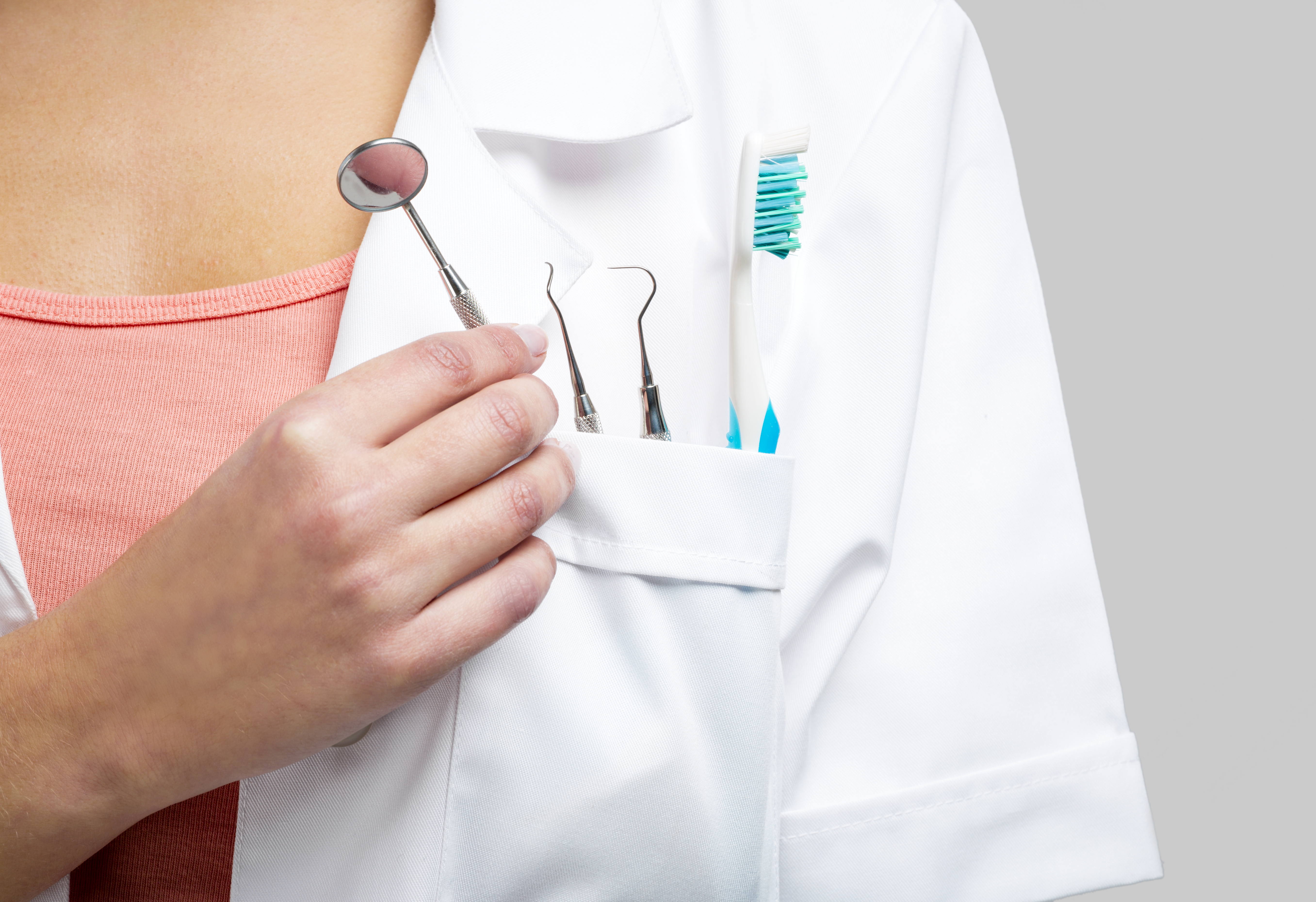 Female dentist with tools, isolated over a white background